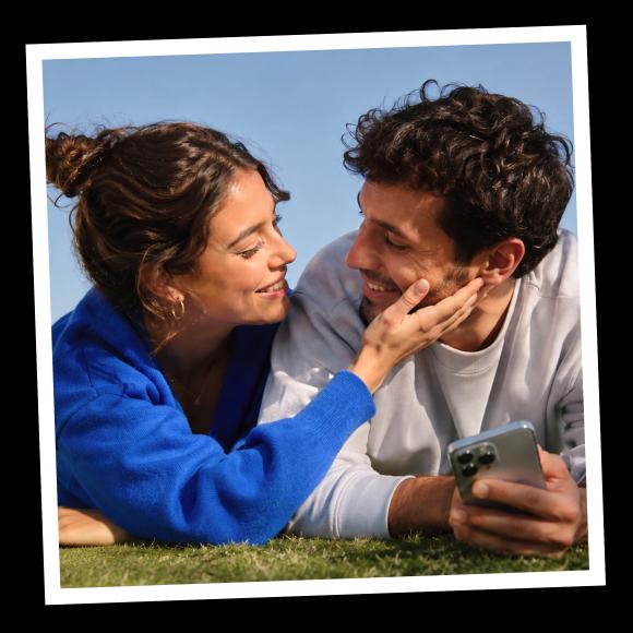 A happy couple lays on the grass