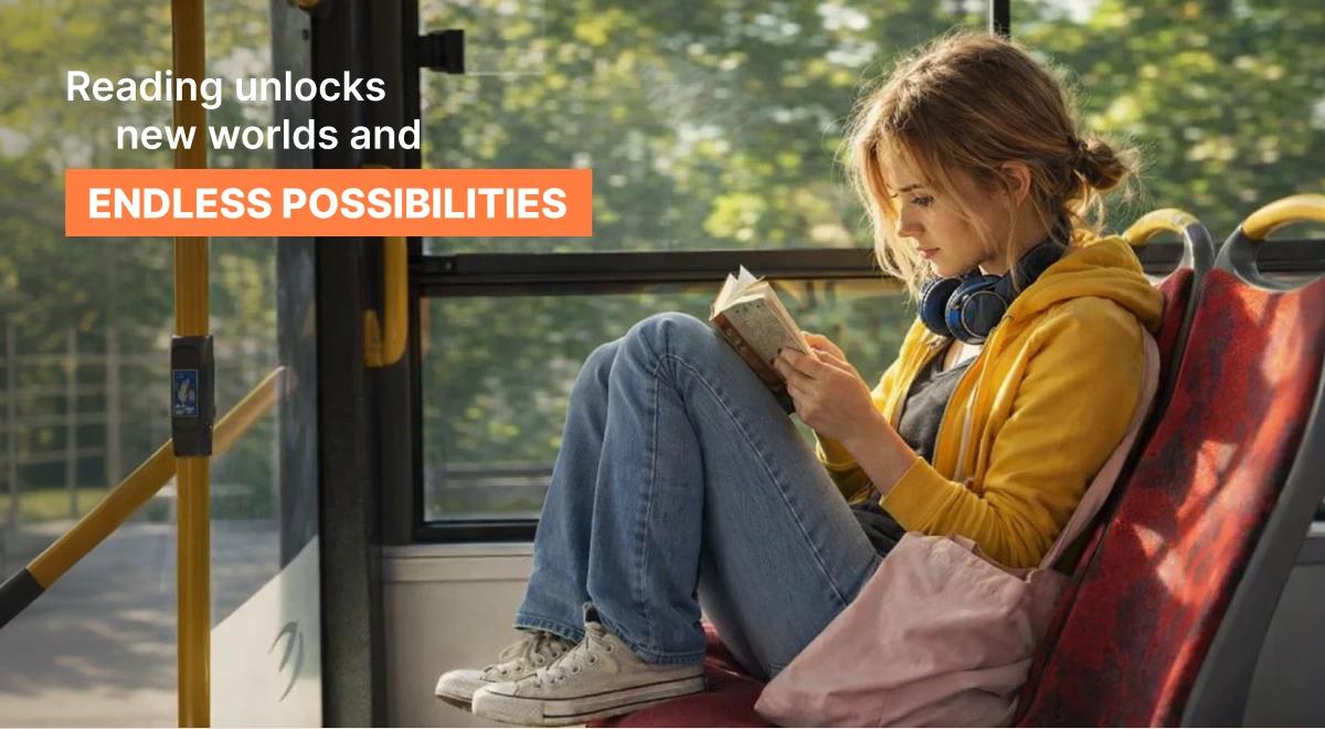 Young woman in a yellow hoodie with blue headphones reading book recommendations while sitting on a bus seat with green trees in the background