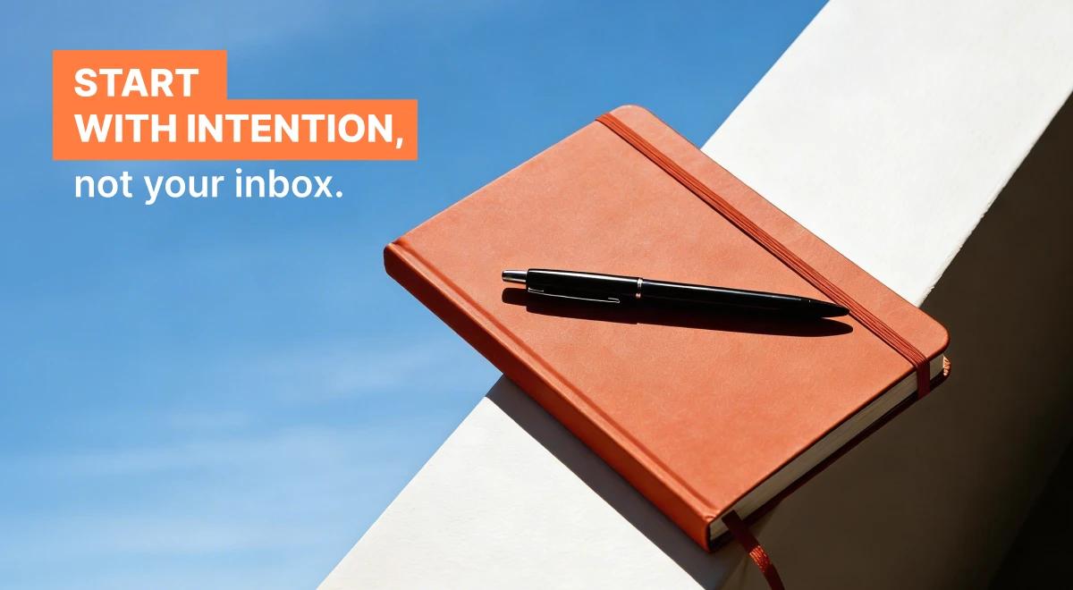 Orange leather notebook with a black pen resting on a geometric surface against a blue sky background, representing intentional leadership and CEO skills