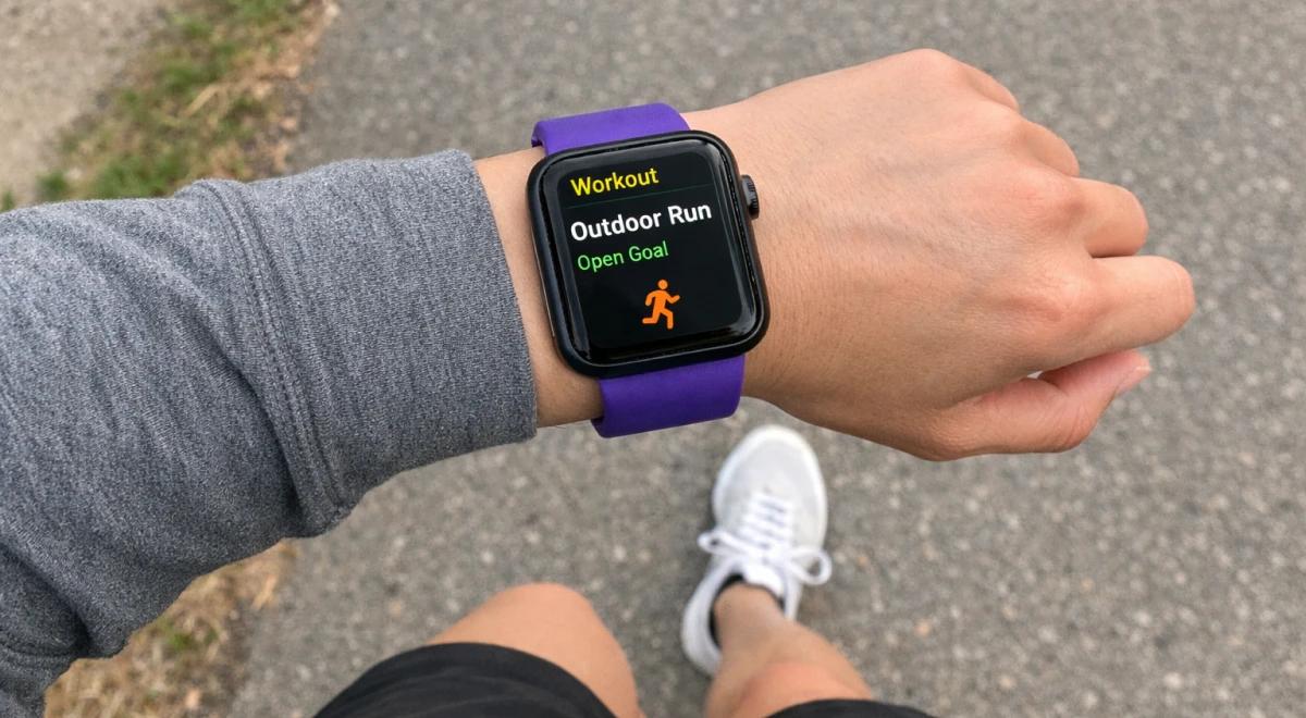 Person wearing Apple Watch with purple band displaying Outdoor Run workout on pavement, reflecting David Goggins daily routine built on mental toughness and discipline