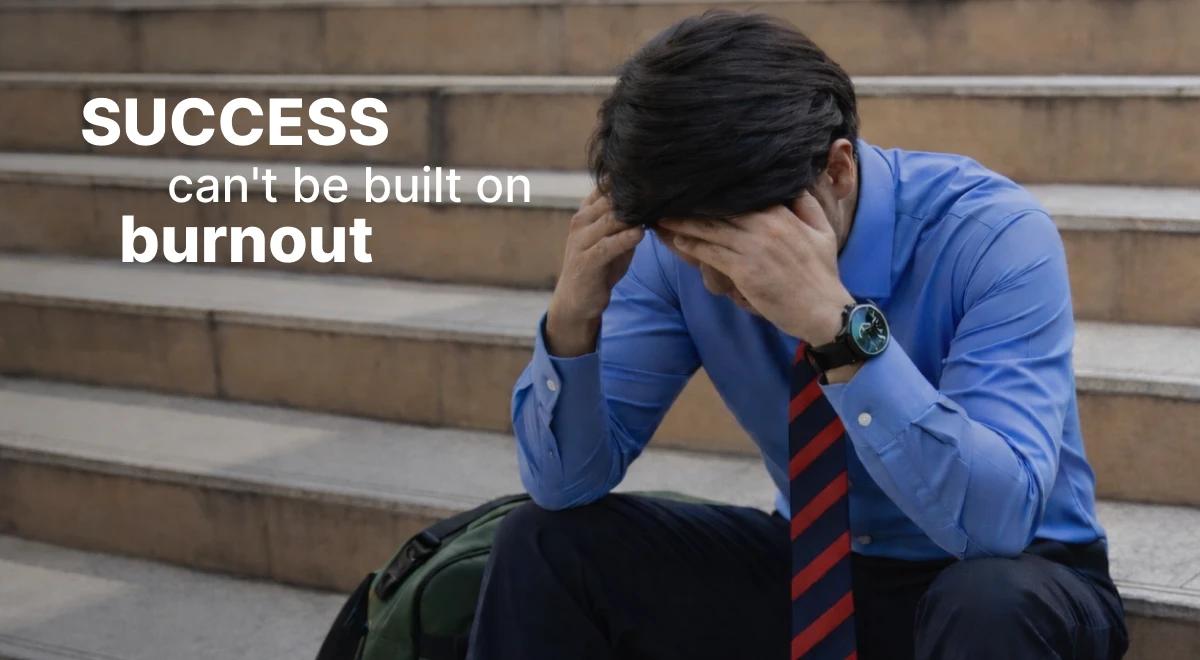 Stressed businessman in blue shirt and tie sitting on stairs with head in hands, showing burnout as a barrier to entrepreneurs time management and sustainable success