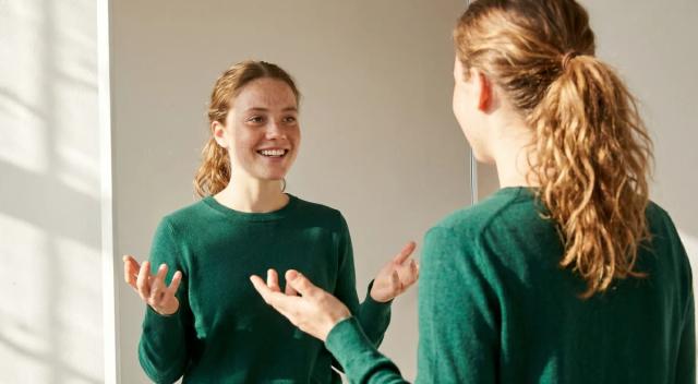 young women in green sweaters having an animated conversation with hand gestures in a bright room, representing active listening and communication skills