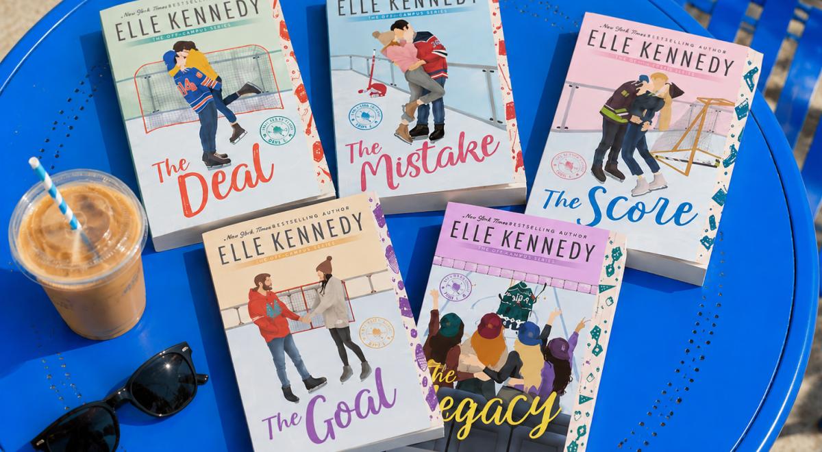 Elle Kennedy's Off-Campus book series paperbacks including The Deal, The Mistake, The Score, The Goal and The Legacy arranged on a blue table beside an iced coffee and sunglasses