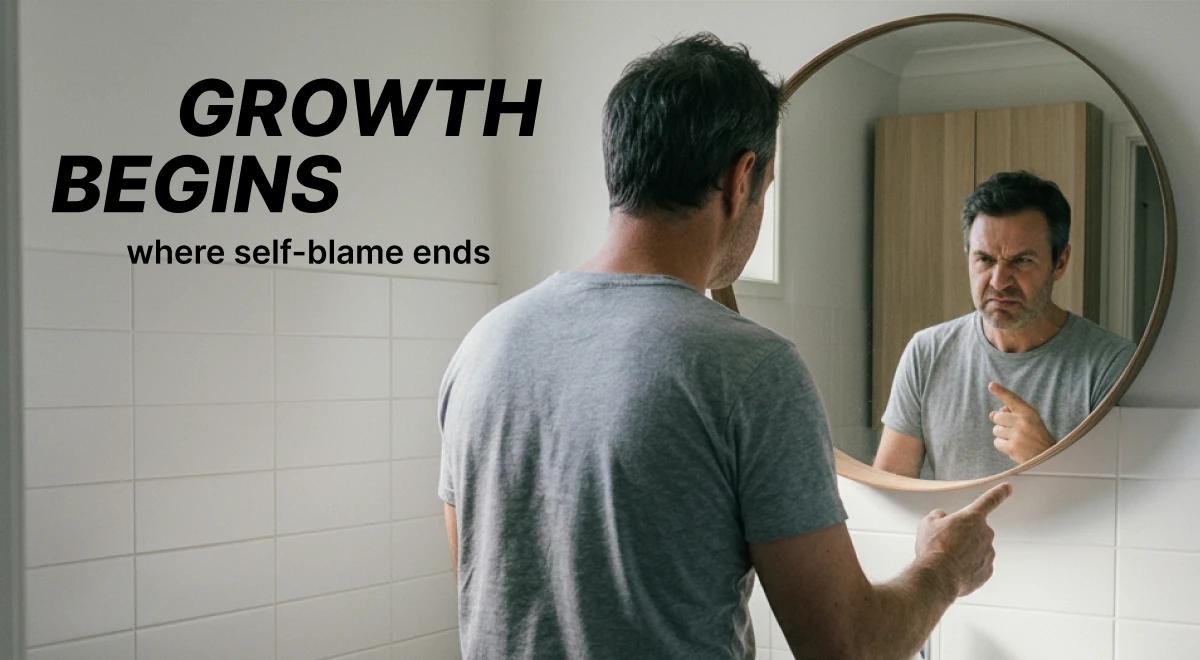 Man in a gray t-shirt pointing at his reflection in a round bathroom mirror, symbolizing the journey to overcome self-blame and reclaim self-esteem