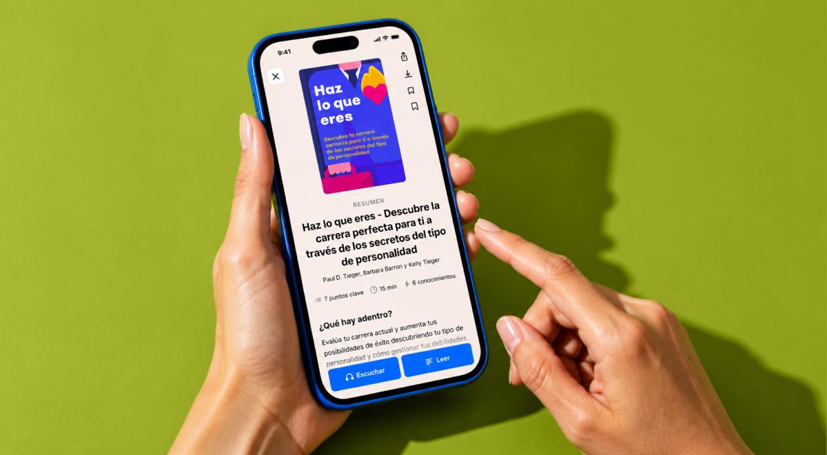 Manos sosteniendo un smartphone con la aplicación Headway abierta mostrando el resumen del libro Haz lo que eres sobre fondo verde
