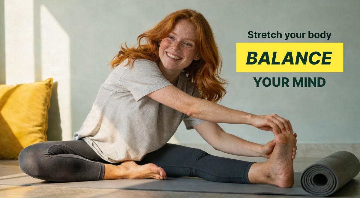 Redhead woman in a gray t-shirt stretching on a yoga mat indoors with yellow pillows in the background, promoting dopamine reset and mental well-being