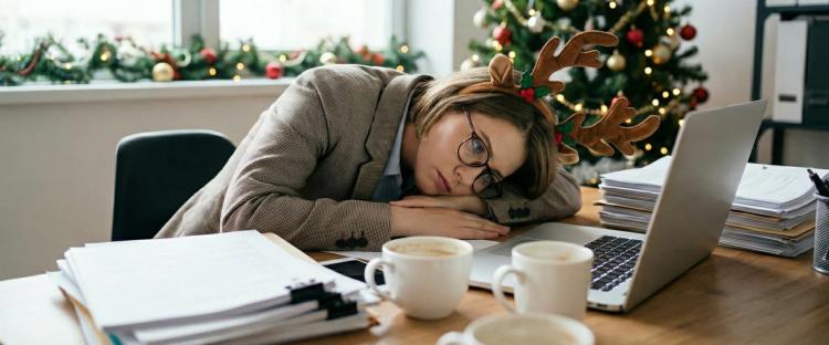 A woman in deer antler hoop lays with her head on the laptop and feeling 2025 Burnout