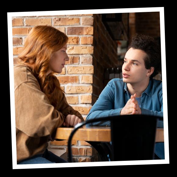 Red headed girl looks down at her boyfriend in blue shirt