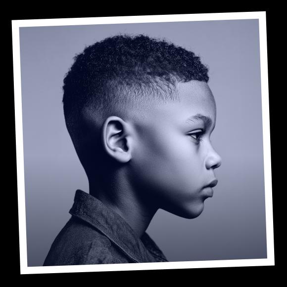 A dark skinned boy with curly hair is staring right side